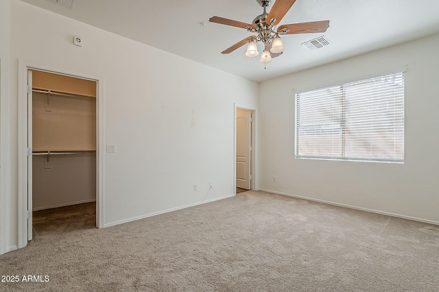 unfurnished bedroom with a spacious closet, carpet floors, a closet, and visible vents