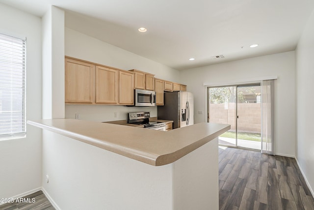 kitchen with stainless steel appliances, dark wood-style flooring, visible vents, and light brown cabinetry