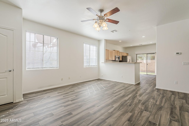 unfurnished living room with dark wood-style floors, recessed lighting, visible vents, ceiling fan, and baseboards