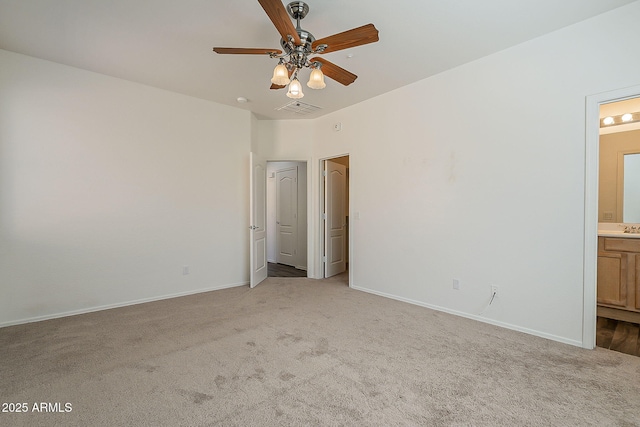 unfurnished bedroom featuring baseboards, visible vents, ensuite bathroom, carpet flooring, and a sink