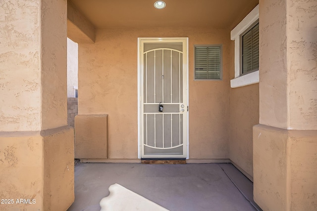 view of exterior entry with stucco siding