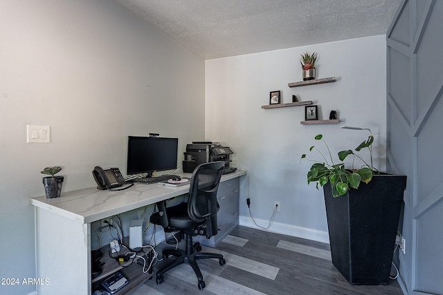 office area with a textured ceiling and dark wood-type flooring