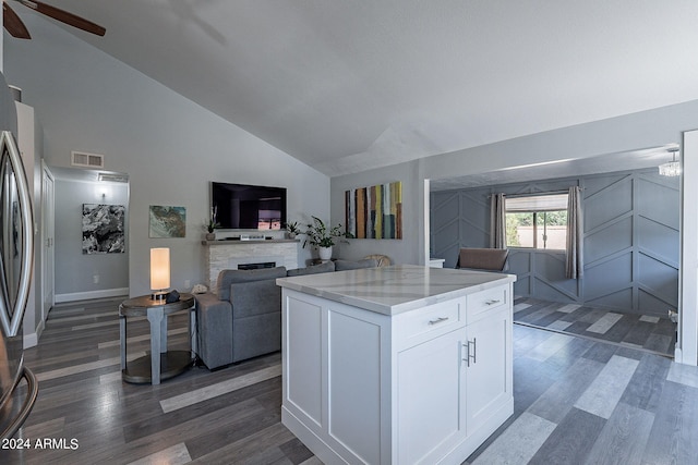 kitchen with lofted ceiling, dark wood-type flooring, white cabinets, ceiling fan, and light stone counters