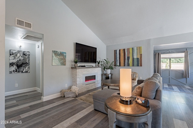 living room with a stone fireplace, wood-type flooring, and high vaulted ceiling