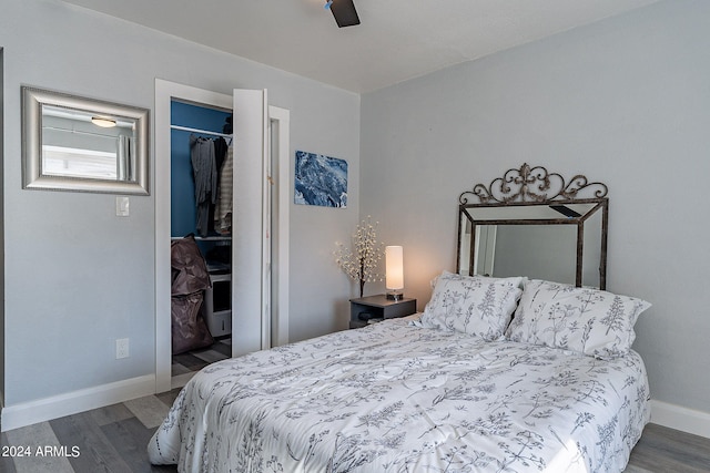 bedroom with hardwood / wood-style floors, a spacious closet, a closet, and ceiling fan