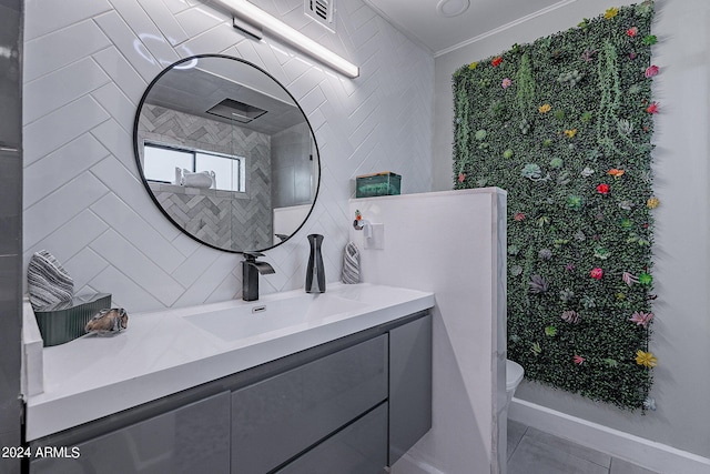 bathroom featuring tile patterned flooring, vanity, toilet, and decorative backsplash