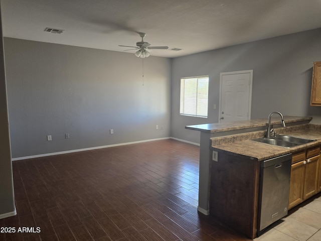 kitchen with dishwashing machine, sink, ceiling fan, a center island with sink, and light wood-type flooring