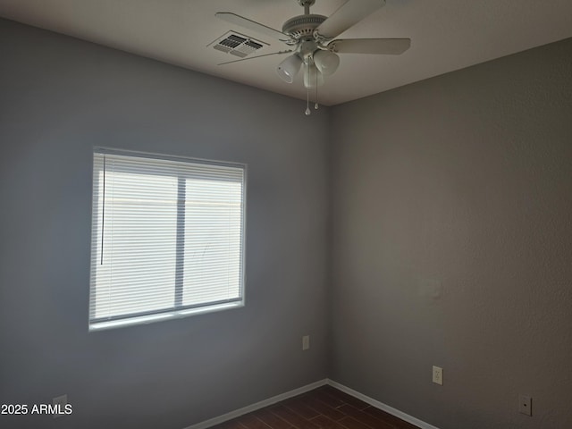 spare room with dark wood-type flooring and ceiling fan