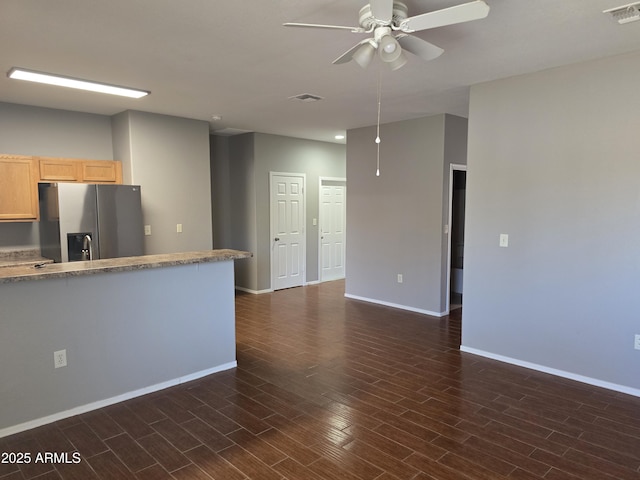 kitchen with ceiling fan, dark wood-type flooring, stainless steel fridge, and light brown cabinetry