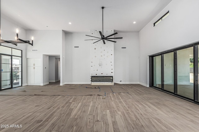 3653 E Runaway Bay Pl, Queen Creek, AZ 85142 - unfurnished living room with a towering ceiling, baseboards, wood finished floors, a ceiling fan, and recessed lighting