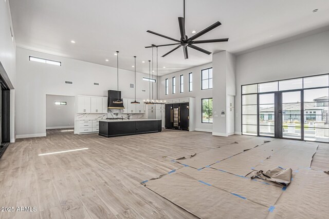 3653 E Runaway Bay Pl, Queen Creek, AZ 85142 - living room with a towering ceiling, ceiling fan, recessed lighting, baseboards, and light wood-style flooring