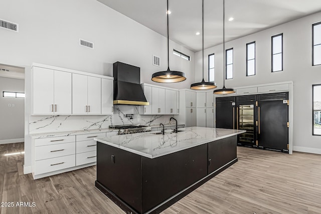 3653 E Runaway Bay Pl, Queen Creek, AZ 85142 - kitchen with wall chimney exhaust hood, a high ceiling, paneled fridge, baseboards, and range