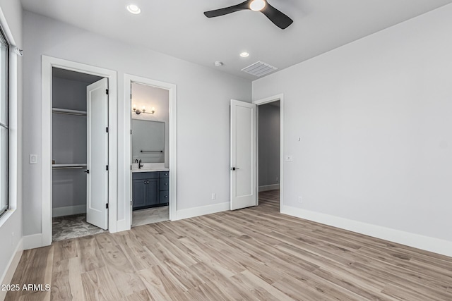 3653 E Runaway Bay Pl, Queen Creek, AZ 85142 - unfurnished bedroom featuring a spacious closet, light wood-style floors, a closet, baseboards, and ensuite bath