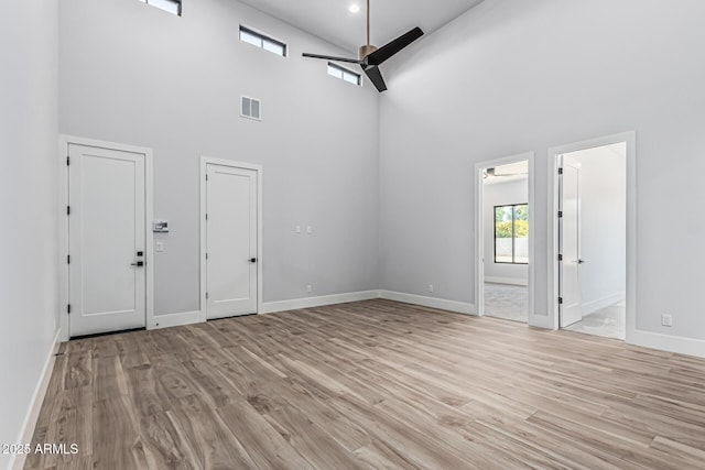 3653 E Runaway Bay Pl, Queen Creek, AZ 85142 - unfurnished room with a ceiling fan, a towering ceiling, light wood-style flooring, and baseboards