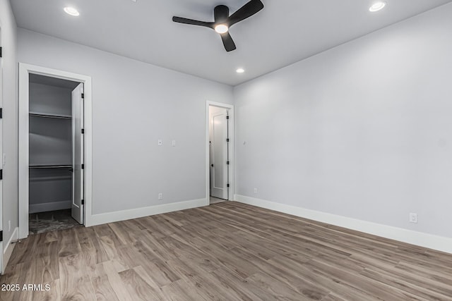 3653 E Runaway Bay Pl, Queen Creek, AZ 85142 - unfurnished bedroom featuring wood finished floors, baseboards, a walk in closet, recessed lighting, and ceiling fan