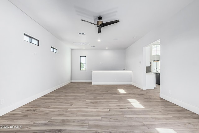 3653 E Runaway Bay Pl, Queen Creek, AZ 85142 - unfurnished living room featuring ceiling fan, light wood-style floors, baseboards, and recessed lighting