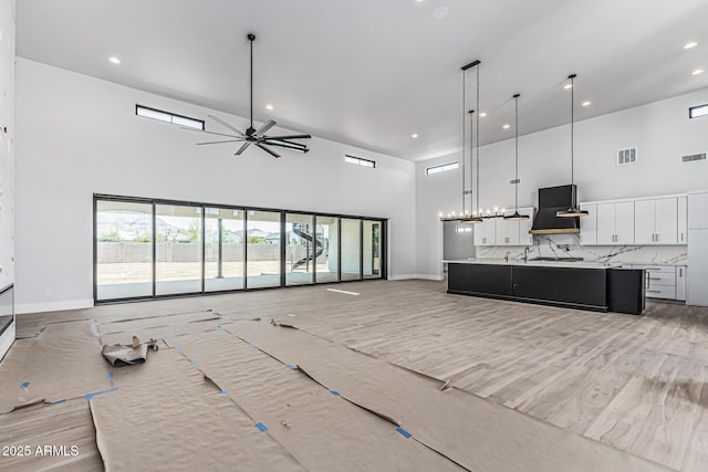 3653 E Runaway Bay Pl, Queen Creek, AZ 85142 - unfurnished living room with a towering ceiling, recessed lighting, a ceiling fan, and baseboards