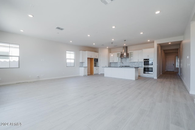 unfurnished living room with light wood-type flooring and sink