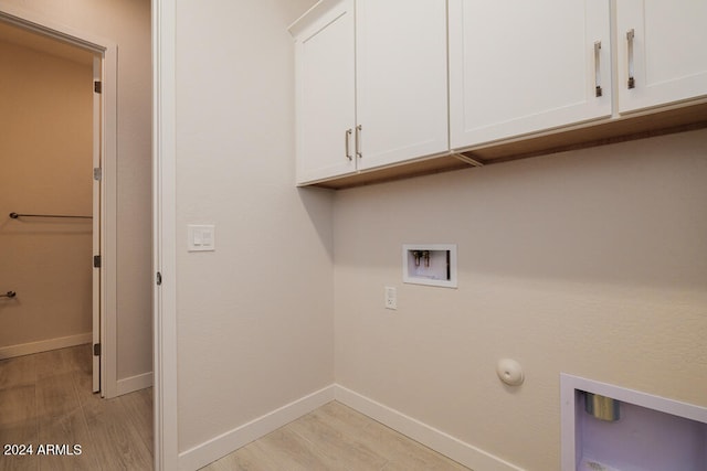 washroom featuring cabinets, hookup for a washing machine, hookup for a gas dryer, and light hardwood / wood-style flooring