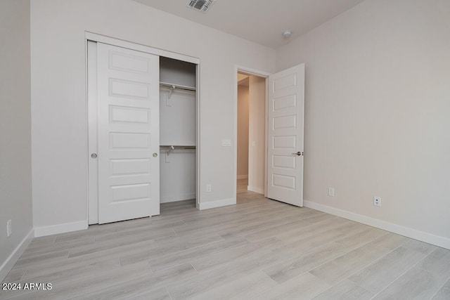 unfurnished bedroom with a closet and light hardwood / wood-style flooring