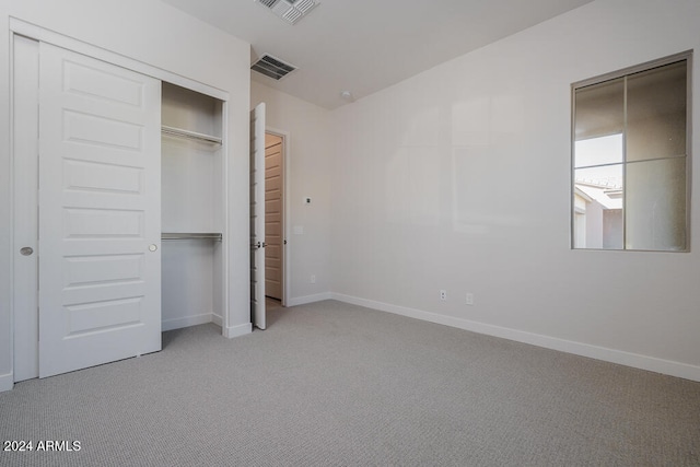 unfurnished bedroom with light carpet and a closet