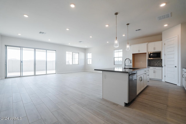 kitchen featuring a kitchen island with sink, sink, white cabinets, and stainless steel appliances