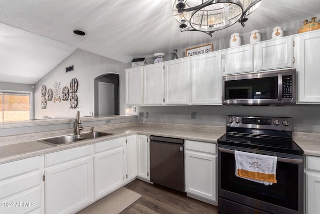 kitchen with white cabinetry, sink, dark wood-type flooring, vaulted ceiling, and appliances with stainless steel finishes