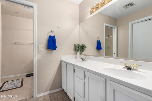 bathroom with tile patterned flooring, vanity, and a shower with door