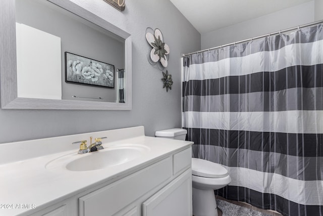 bathroom featuring a shower with shower curtain, vanity, and toilet