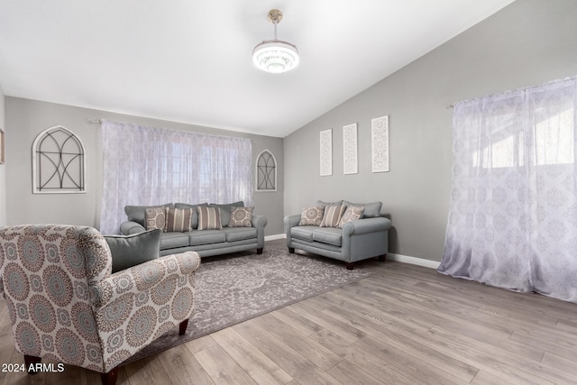 living room featuring light hardwood / wood-style floors and vaulted ceiling