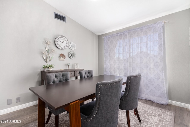 dining area featuring dark wood-type flooring and vaulted ceiling