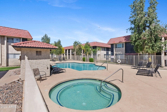 view of swimming pool with a hot tub and a patio