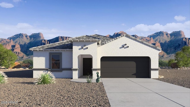 view of front of house featuring stucco siding, a garage, a mountain view, and concrete driveway