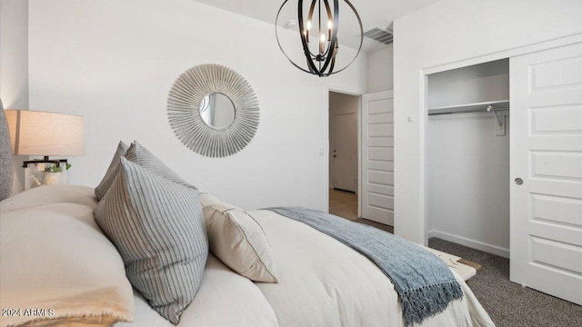 carpeted bedroom with baseboards, an inviting chandelier, visible vents, and a closet