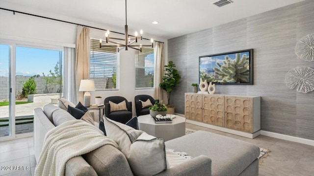 living area featuring baseboards, an accent wall, visible vents, and a chandelier