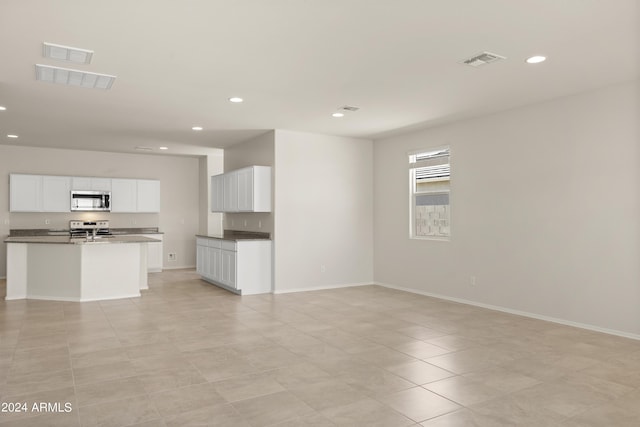 unfurnished living room featuring visible vents, recessed lighting, and baseboards
