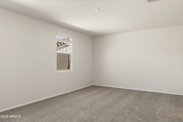 unfurnished room with baseboards, carpet, and visible vents