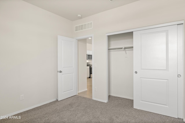 unfurnished bedroom with carpet floors, baseboards, visible vents, and a closet