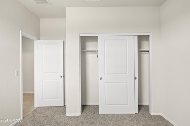 unfurnished bedroom with baseboards, carpet, a closet, and visible vents