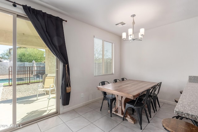 dining room with a chandelier, light tile patterned floors, visible vents, and baseboards