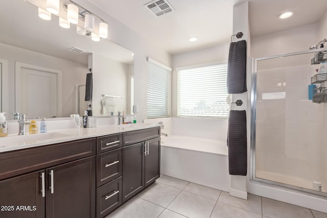 full bathroom featuring visible vents, a sink, a shower stall, tile patterned flooring, and double vanity