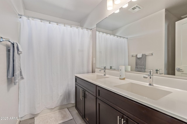 bathroom with tile patterned flooring, double vanity, visible vents, and a sink