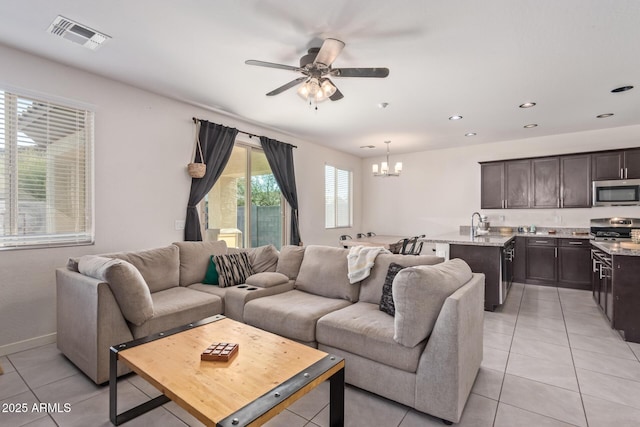 living area featuring visible vents, baseboards, ceiling fan with notable chandelier, recessed lighting, and light tile patterned flooring