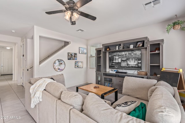 living room featuring light tile patterned flooring, visible vents, and a ceiling fan