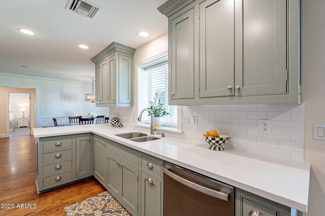 kitchen featuring visible vents, gray cabinetry, a sink, stainless steel dishwasher, and a peninsula