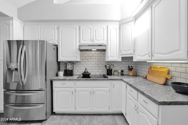 kitchen featuring black electric cooktop, stainless steel fridge, and white cabinets