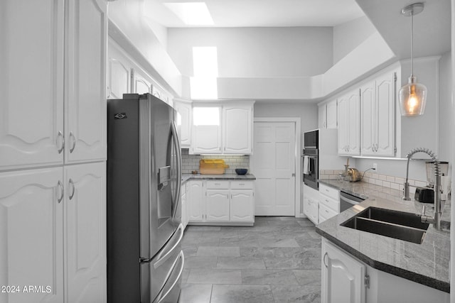 kitchen featuring tasteful backsplash, sink, white cabinets, hanging light fixtures, and stainless steel appliances