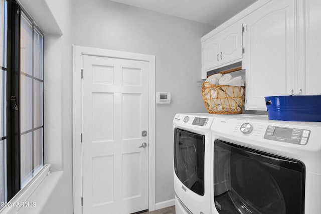 washroom with cabinets and washer and dryer