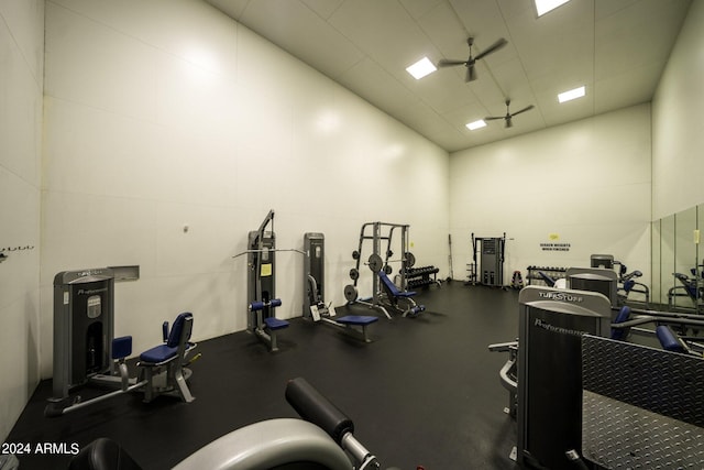 exercise room featuring a high ceiling and ceiling fan