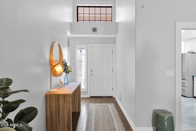 foyer with a high ceiling and hardwood / wood-style flooring